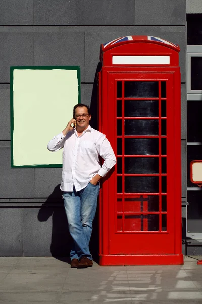 Homem de negócios usando telefone celular vermelho clássico Inglês telefone bo — Fotografia de Stock