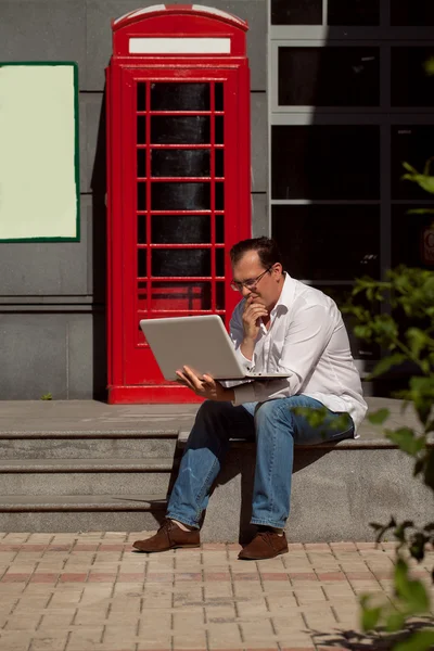 Homem de negócios usando telefone celular vermelho clássico Inglês telefone bo — Fotografia de Stock