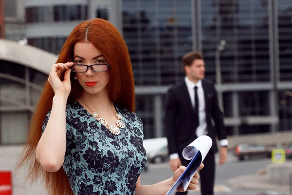 Mujer pelirroja posando sobre saltos de fondo de hombre de negocios — Foto de Stock