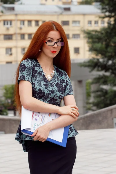 Jonge Glimlachende zakenvrouw met hoop papieren — Stockfoto