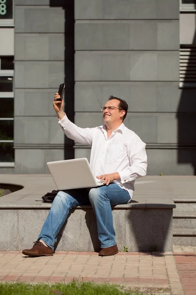 Erwachsener Mann mit Computer sitzt im Freien sonnigen Tag — Stockfoto