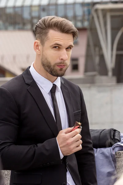 Joven hombre de negocios comiendo chocolate — Foto de Stock