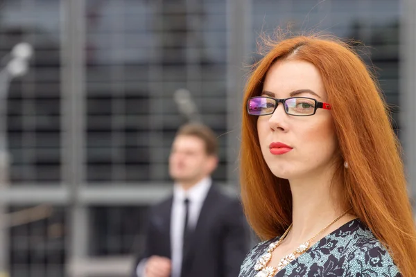 Pelirroja mujer posando en saltar fondo de hombre de negocios —  Fotos de Stock