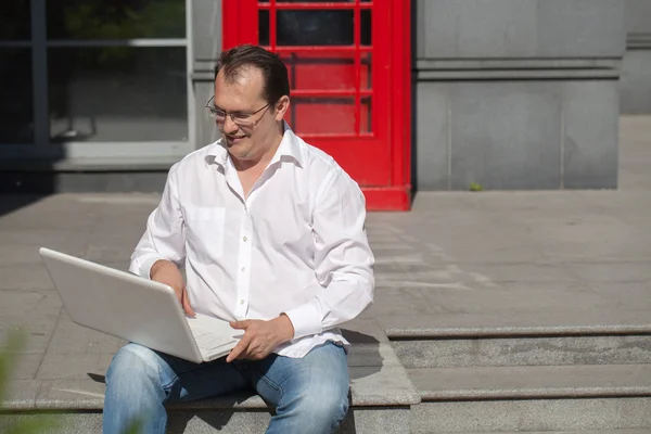 Geschäftsmann auf roter klassischer englischer Telefonzelle — Stockfoto