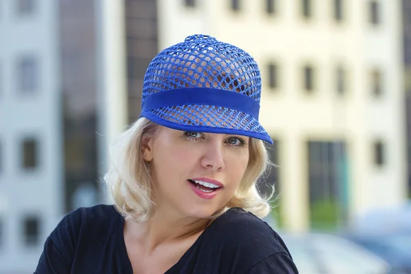漂亮的金发的成年女性，构成在现代蓝帽子 — 图库照片