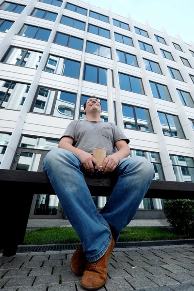 Stijl van de stad. Knappe volwassen man in vrijetijdskleding bedrijf drinken — Stockfoto