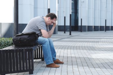 Beyaz ofis binası önünde üzgün adam