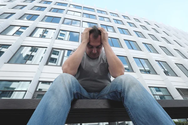 Triste hombre frente al edificio de oficinas blanco — Foto de Stock