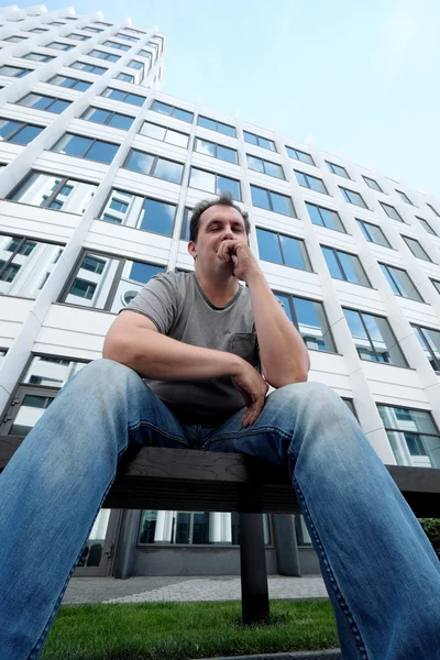 Homem triste na frente do prédio de escritórios branco — Fotografia de Stock