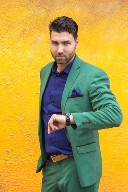 Sarı duvar zemin üzerine yeşil elbiseli adam.
