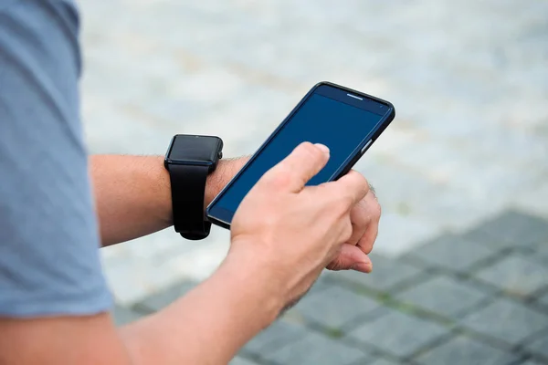 Mann checkt draußen seine Smartwatch. Schuss aus spitzem Winkel. — Stockfoto