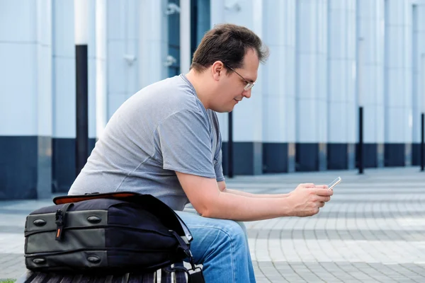 Schöner erwachsener Mann in Freizeitkleidung mit Handy-Kaffee in f — Stockfoto