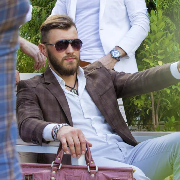 Elegant skäggig man sitter utomhus. — Stockfoto