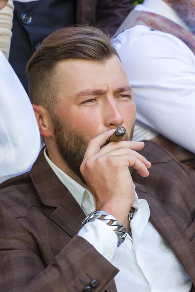 Eleganter bärtiger Mann, der eine Zigarre raucht — Stockfoto