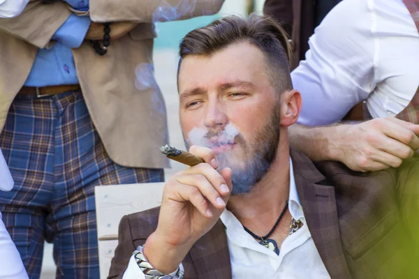 Eleganter bärtiger Mann, der eine Zigarre raucht — Stockfoto