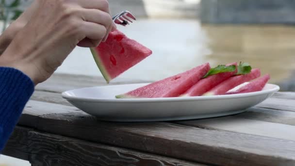 Kvinnan rensar skivor av röd vattenmelon i gatan caffe — Stockvideo
