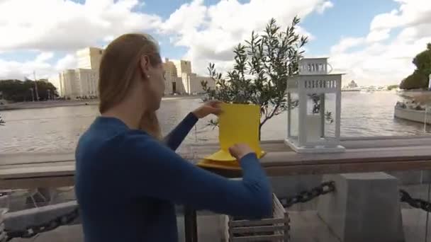 Joven mujer feliz menú de lectura en la calle café el día de otoño — Vídeos de Stock