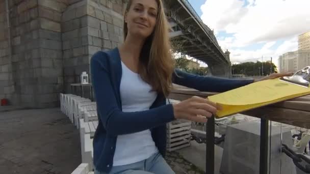 Joven mujer feliz menú de lectura en la calle café el día de otoño — Vídeos de Stock