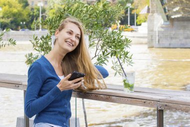Kafe cep telefonu konuşma kokteyl ile güzel kadın.