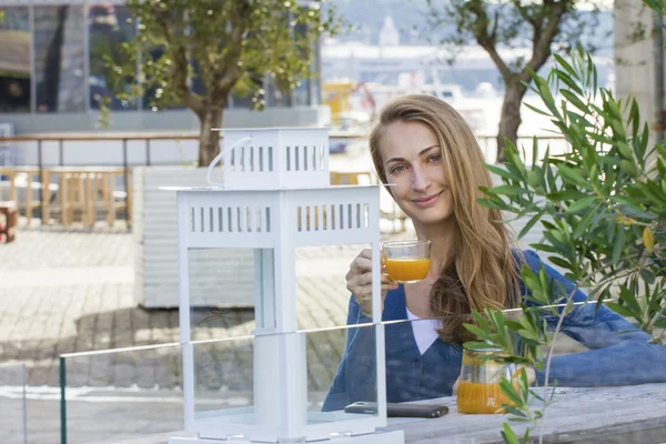 Woman with tea cup. Tea with sea buckthorn and honey on cafe bac