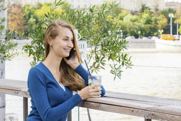 Belle femme avec cocktail dans le café téléphone mobile parlant . — Photo