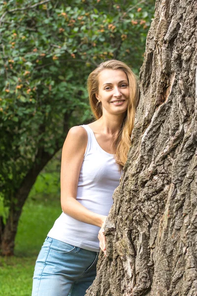 Düşünceli, genç, doğa düşkünü, kocaman bir ağaca sarılan kadın. — Stok fotoğraf