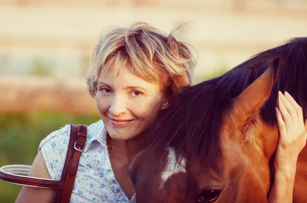 Kobieta uścisk brązowy koń — Zdjęcie stockowe