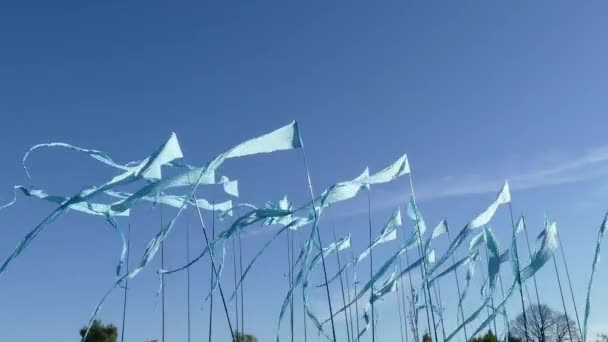 Schwenkschuss vor einem klaren blauen Himmel Hintergrund aus bunten String-Wimpel-Dreieck-Fahnen, die für Feiern oder große Eröffnungen im Wind verwendet werden. — Stockvideo