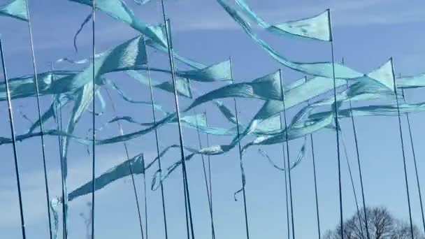 Panoramique sur fond de ciel bleu clair de drapeaux triangulaires fanions de ficelle colorés utilisés pour les célébrations ou les grandes ouvertures soufflant dans le vent . — Video