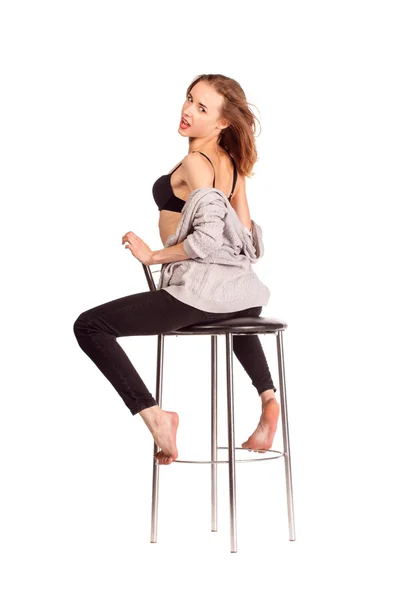 Portrait of pretty women in studio, sitting on a bar chair in un — Stock Photo, Image