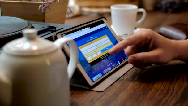 Homem escolhe hotel através da aplicação Booking.com em um Tablet PC — Vídeo de Stock