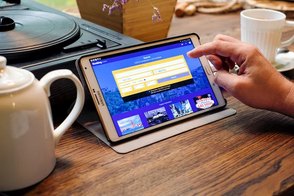 Hombre elige hotel a través de la aplicación Reserva en una Tablet PC — Foto de Stock
