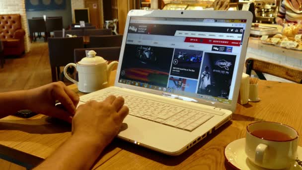 Página web Indycar en la pantalla del ordenador portátil en la cafetería — Vídeo de stock