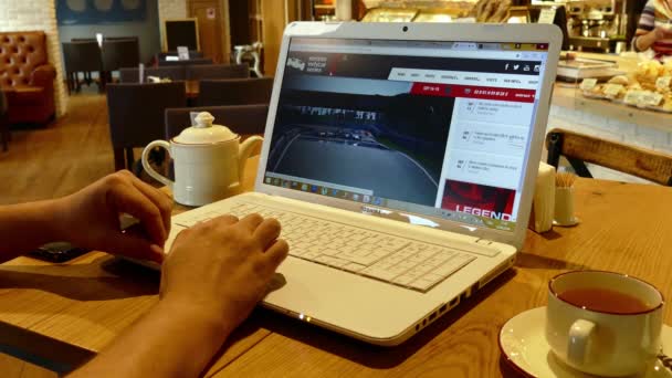 Página web Indycar en la pantalla del ordenador portátil en la cafetería — Vídeo de stock