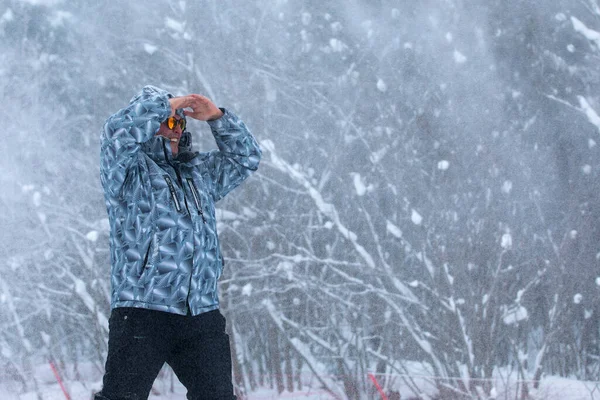 L'homme se tient seul contre la tempête de neige blanche et la tempête de neige, une chute de neige. — Photo