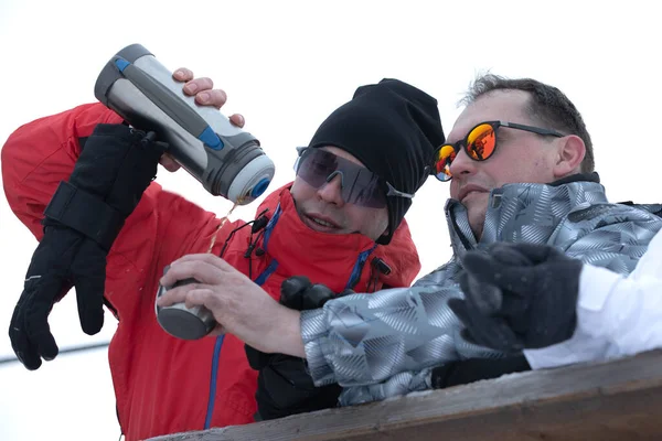 Bir grup arkadaş kayak merkezindeki kafede sıcak sıcak şarabın tadını çıkarıyorlar. — Stok fotoğraf