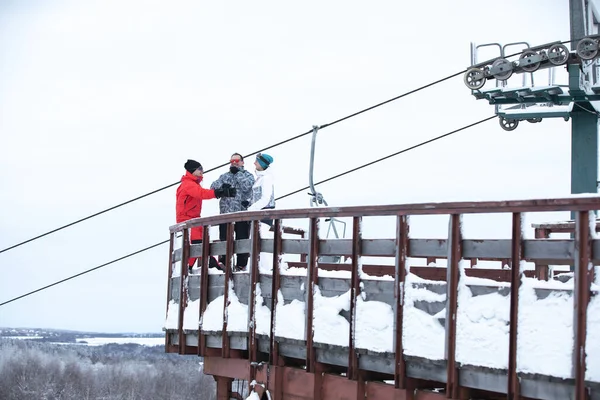 Skiers posing against the background of the ski lift — Stock Photo, Image