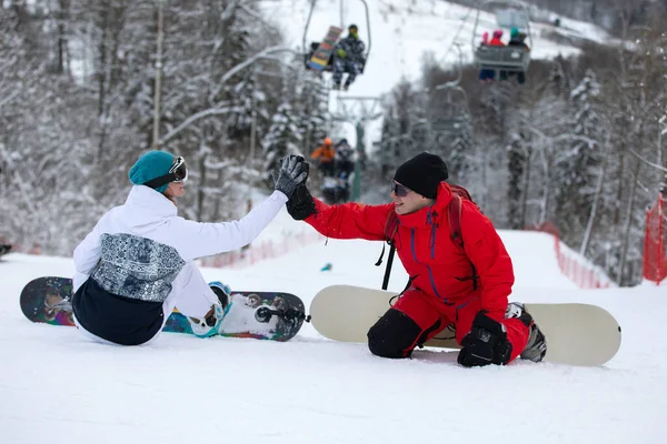 Dois pilotos de snowboard sentam-se em uma encosta — Fotografia de Stock