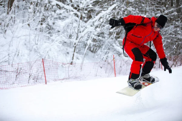 Snowboard binicisi hızlı bir şekilde karlı dağ yamacına doğru gidiyor. Palyaço kışı günü beyaz kar yağıyor.. — Stok fotoğraf