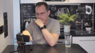 İş adamı evde çalışan kameraya bakıyor