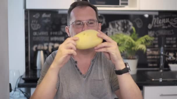 Man sniffs mango — Stock Video