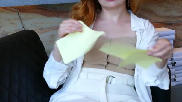Mujer nerviosamente rompe el papel en pequeños pedazos mientras está sentada en la oficina. — Vídeo de stock