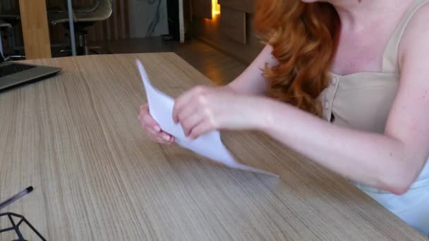 Kadın ofiste otururken gergin bir şekilde kağıdı küçük parçalara ayırıyor.. — Stok video