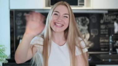 İş kadını evde çalışan kameraya bakıyor.