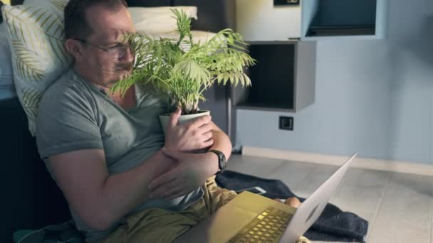 Uomo guardando un film horror abbracciare con un fiore di casa — Video Stock