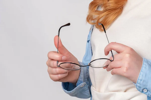 Mulher de gengibre segura óculos nas mãos — Fotografia de Stock