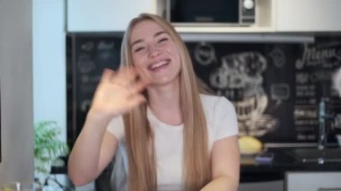 İş kadını evde çalışan kameraya bakıyor.