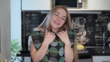 Evde çalışan bir kadın kameraya bakıyor.