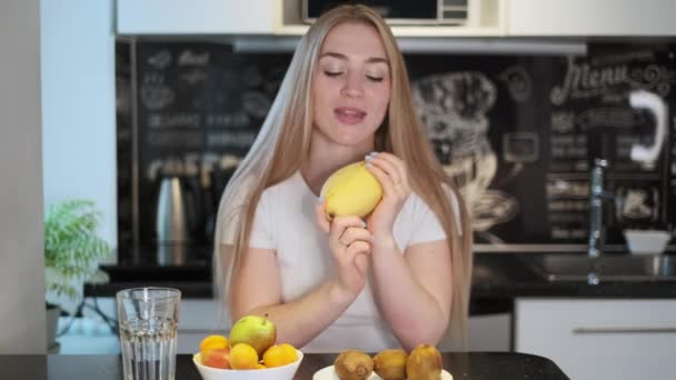 Mujer huele mango amarillo fresco — Vídeos de Stock
