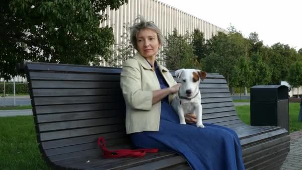 Kvinna sitter i parken med gravid hund — Stockvideo